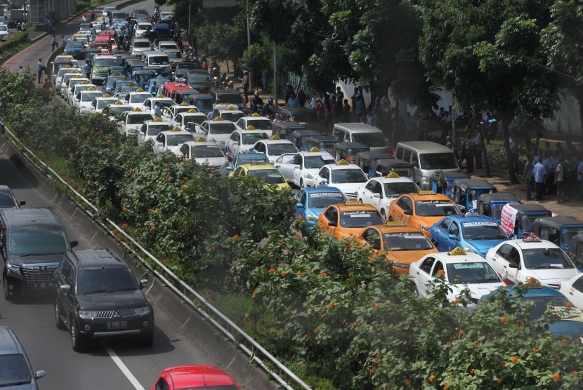 Ratusan angkutan umum jenis taksi terparkir diruas jalan Semanggi saat melakukan unjuk rasa di kawasan Senayan, Jakarta, Selasa (22/3).