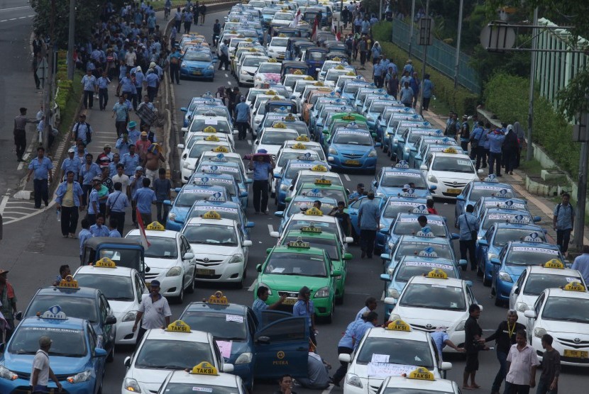 Ratusan angkutan umum jenis taksi terparkir diruas jalan Semanggi saat melakukan unjuk rasa di kawasan Senayan, Jakarta, Selasa (22/3).