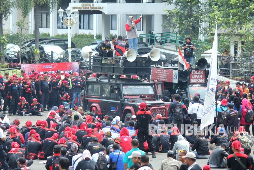 Ratusan buruh dari Federasi Serikat Pekerja Metal Indonesia (FSPMI) menggelar aksi di depan Gedung Sate, Kota Bandung, Jumat (26/1). Aksi tersebut menuntut Pemerintah Provinsi segera menetapkan Upah Minimum Sektoral Kabupaten Kota (UMSK) 2018.