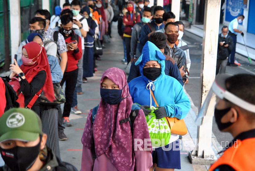 Ratusan calon penumpang KRL Commuter Line mengantre menuju pintu masuk Stasiun Bogor di Jawa Barat, Senin (8/6/2020). Antrean panjang calon penumpang tersebut terjadi saat dimulainya aktivitas perkantoran di Jakarta di tengah masa transisi Pembatasan Sosial Berskala Besar (PSBB) pandemi COVID-19.