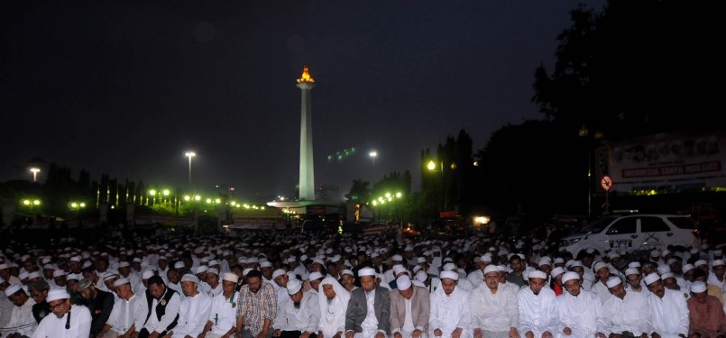 Ratusan Massa Forum Umat Islam (FUI) melaksanakan salat Maghrib saat berunjuk rasa di depan Istana Merdeka, Jakarta, Jumat (30/3). (Republika/Prayogi)