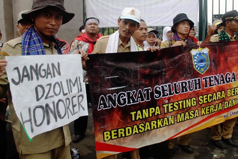   Ratusan massa yang tergabung dalam Forum Tenaga Honorer melakukan aksi unjuk rasa di depan Gedung DPR RI, Jakarta Pusat, Jumat (14/3). (Republika/Yasin Habibi)