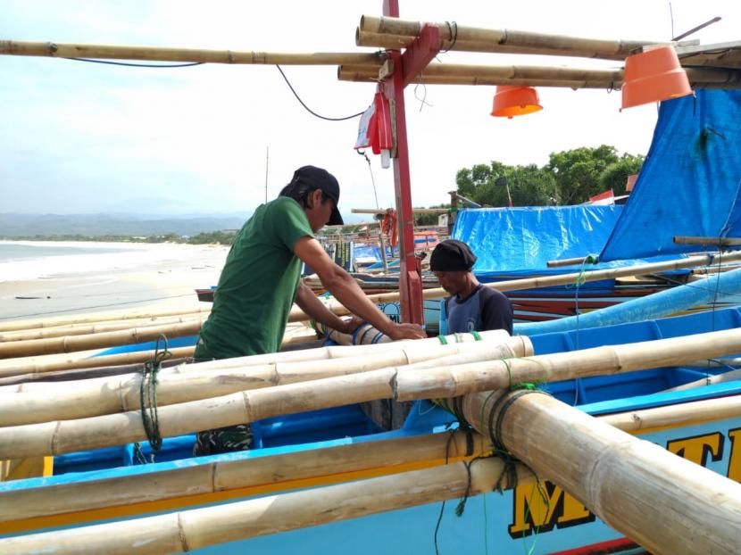 Ratusan nelayan diparkirkan di Pantai Santolo, Kecamatan Cikelet, Kabupaten Garut, Rabu (14/10). Para nelayan masih belum berani memarkirkan perahunya di muara Sungai Cilauteureun khawatir banjir bandang susulan. 
