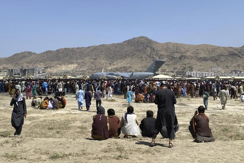 Ratusan orang berkumpul di dekat pesawat angkut C-17 Angkatan Udara AS di perimeter bandara internasional di Kabul, Afghanistan, Senin, 16 Agustus 2021. 