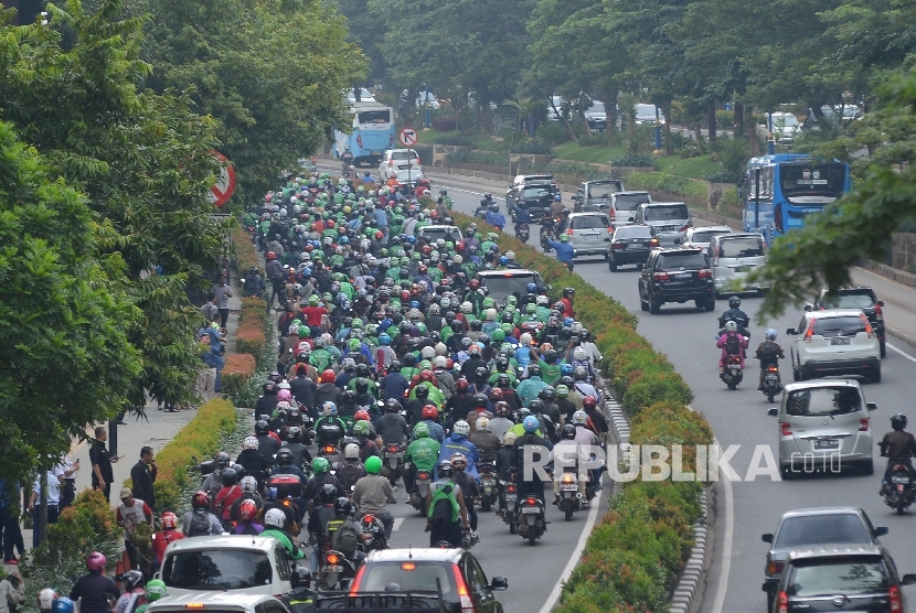  Ratusan pengemudi Gojek melintasi Jalan Rasuna Said saat konvoi menuju Monas, Jakarta Pusat, Selasa (22/3).