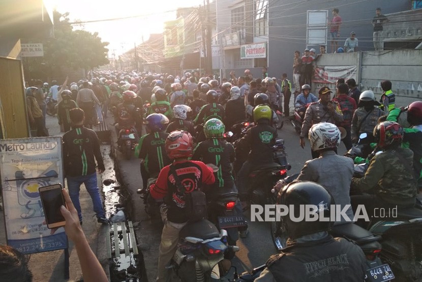 Ratusan pengemudi ojek online melakukan aksi solidaritas di jalan raya Bojongsoang, Kabupaten Bandung, Jumat (27/7). Mereka mendatangi jalan Cikoneng, tempat kejadian terjadinya pemukulan oleh oknum ojek pangkalan kepada ojek online.