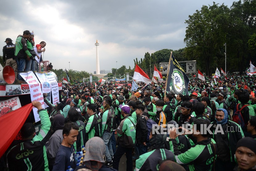  Ratusan pengemudi ojek online (Ojol) melakukan aksi unjuk rasa di depan Istana Merdeka, Jakarta, Selasa (27/3).