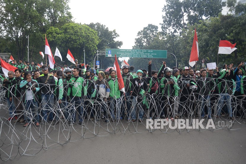  Ratusan pengemudi ojek online (Ojol) melakukan aksi unjuk rasa di depan Istana Merdeka, Jakarta, Selasa (27/3).