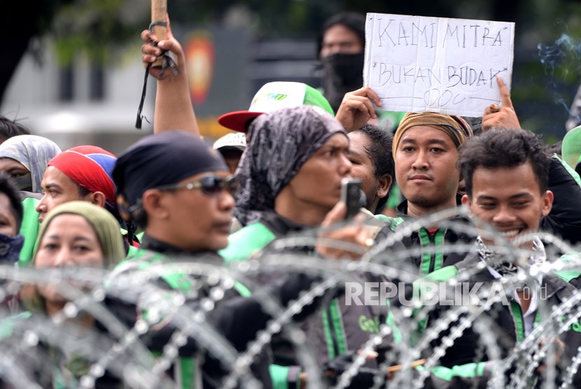  Ratusan pengemudi ojek online (Ojol) melakukan aksi unjuk rasa di depan Istana Merdeka, Jakarta, Selasa (27/3).