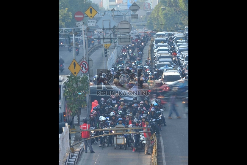 Ratusan pengendara sepeda motor ngotot memasuki jalur busway yang ditutup oleh petugas di jalur TransJakarta di kawasn Mampang Prapatan, Jakarta Selatan, Kamis (4/9).
