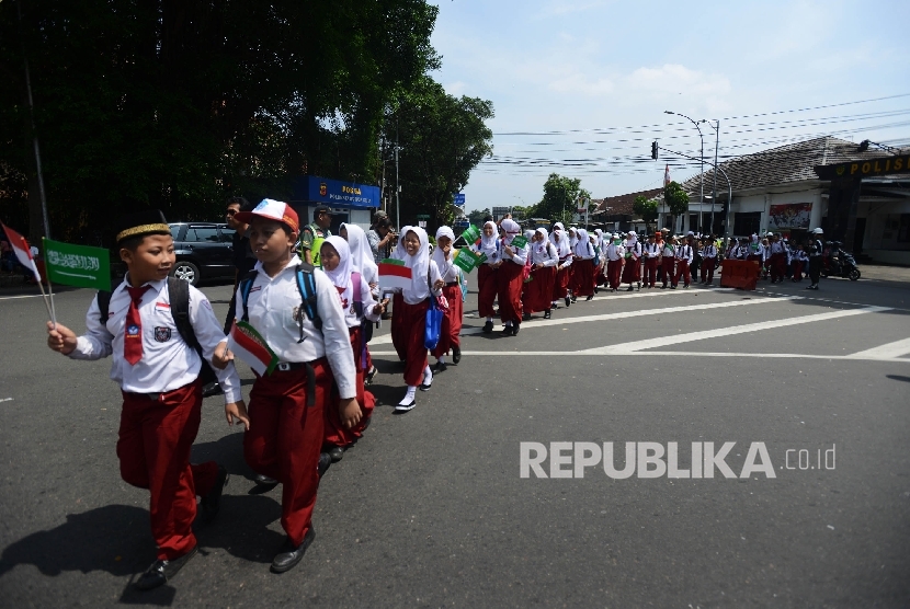 Ratusan siswa SD menyeberang untuk menyambut kedatangan Raja Salman di sekitaran Istana Bogor, Jawa Barat, Rabu (1/3).