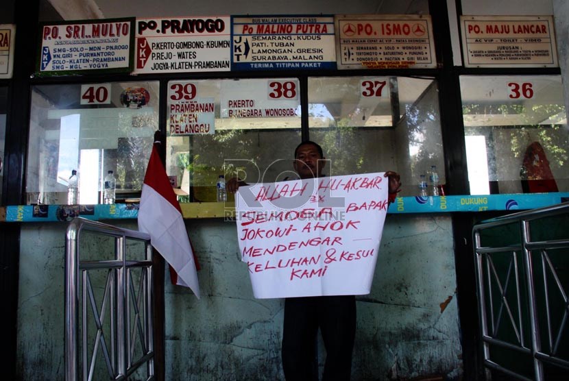    Seorang pengunjuk rasa membawa poster saat menolak penutupan terminal Lebak Bulus, Jakarta, Senin (6/1).    (Republika/Yasin Habibi)