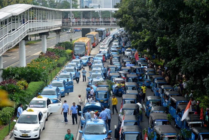 Ratusan supir taksi dan Bajaj melakukan aksi demo menolak keberadaan angkutan umum online di Jalan Jenderal Sudirman, Jakarta, Selasa (22/3).