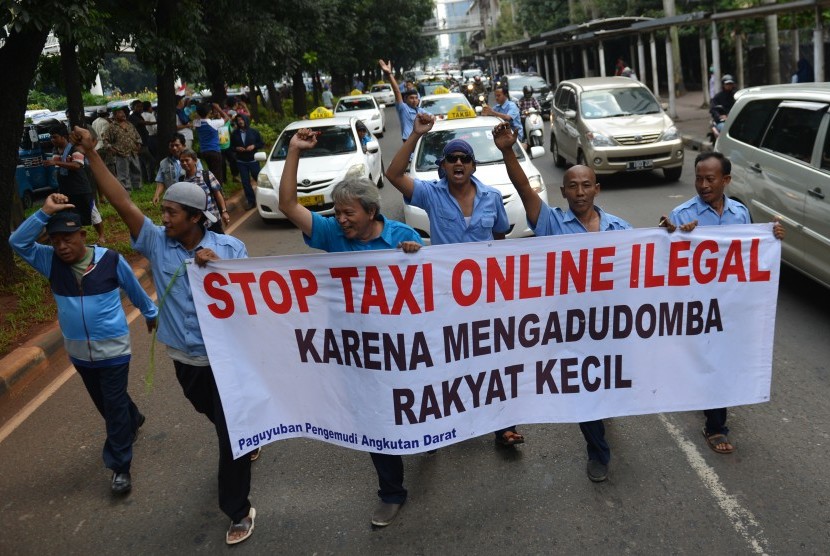 Ratusan supir taksi demo menolak keberadaan angkutan umum online di Jalan Jenderal Sudirman, Jakarta, Selasa (22/3).