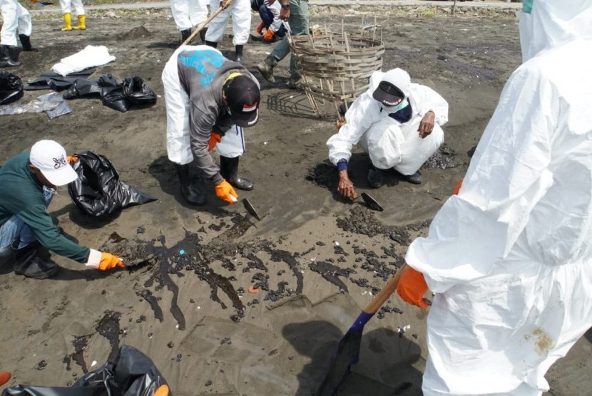 Ratusan warga di Desa Sedari, Kecamatam Cibuaya, Karawang, sedang membersihkan bibir Pantai Sedari dari tumpahan minyak mentah, Selasa (23/7). 