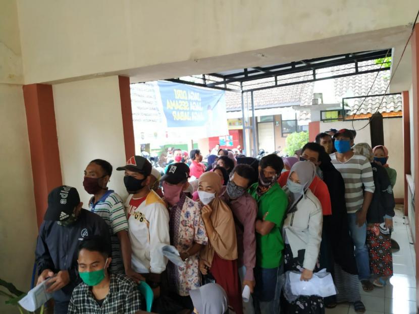 ratusan warga mengantri guna memperoleh bansos di Kelurahan Karsamenak, Kecamatan Kawalu, Kota Tasikmalaya, pada Selasa (19/5), menimbulkan kerumunan. 
