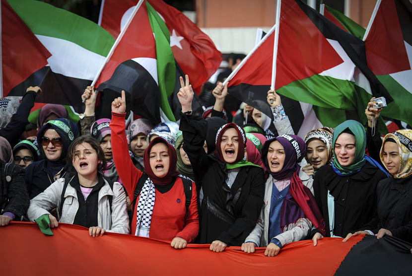 Ratusan warga mengibarkan bendera Turki dan Palestina saat pengadilan Turki melaksanakan sidang in absentia terhadap empat komandan militer Israel di Istanbul, Turki, Selasa (6/11). (foto : AP)