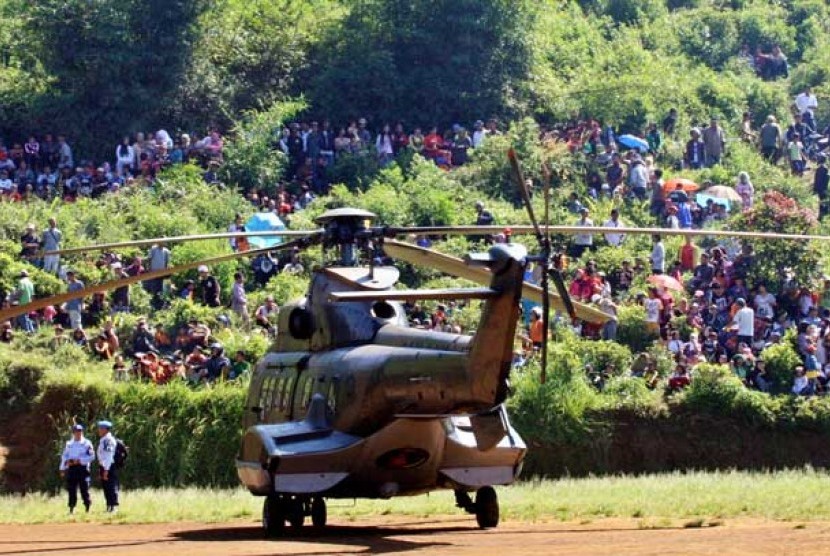  Ratusan warga menonton proses evakuasi jenazah korban pesawat Sukhoi di helipad yang dibangun di kawasan Cijeruk, Bogor, Jawa Barat, Sabtu (12/5).