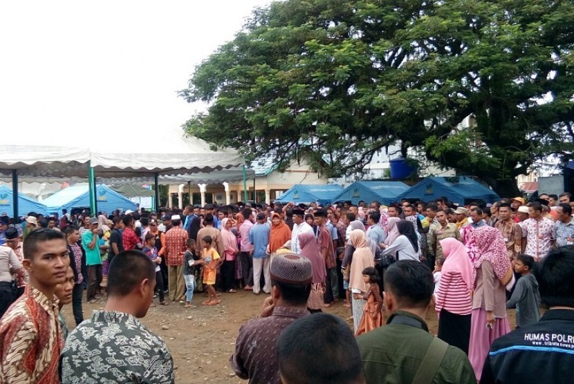 Ratusan warga menunggu kedatangan Presiden Jokowi di masjid At Taqarub, Trienggadeng, Pidie Jaya, Jumat (9/12). Tak sedikit dari mereka yang telah menunggu sejak subuh.