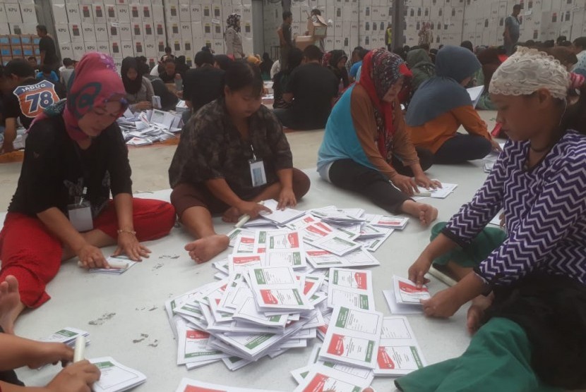 Ratusan warga tengah menyortir dan melipat surat suara pemilu 2019 di Gudang Logistik Komisi Pemilihan Umum (KPU) Kabupaten Bandung di Kampung Sawah, Soreang, Kabupaten Bandung, Kamis (14/3).