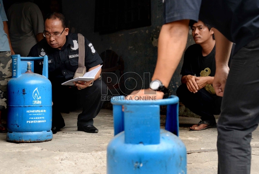 Petugas Krimsus Polda Metro Jaya memeriksa tabung gas elpiji 12 kg di kawasan Kebon Jeruk, Jakarta, Kamis (30/7).  (Republika/Yasin Habibi)