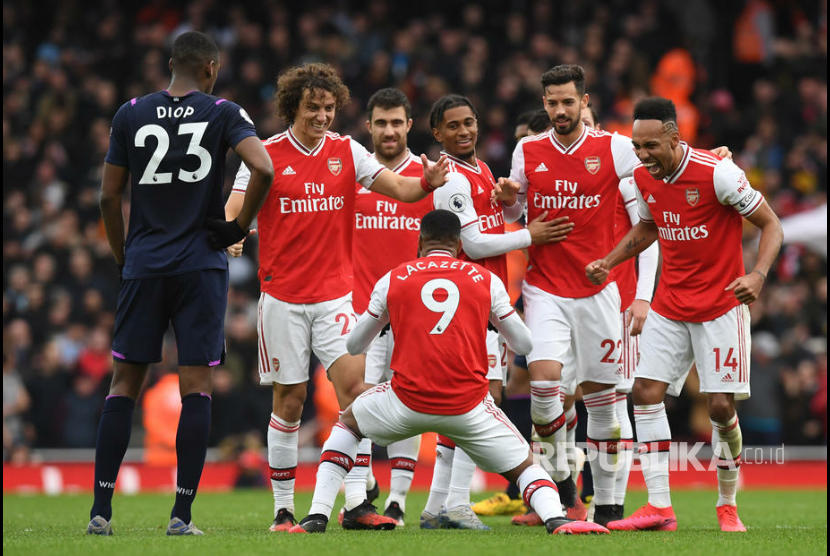 Reaksi Alexandre Lacazette dan tim Arsenal setelah golnya dikonfirmasi oleh wasit VAR pada laga antara Arsenal melawan West Ham United di Emirates Stadium London, Sabtu (7/3) malam. 