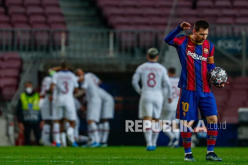 Reaksi pemain Barcelona Lionel Messi (kanan) setelah Kylian Mbappe dari PSG mencetak gol pada babak 16 besar Liga Champions. 