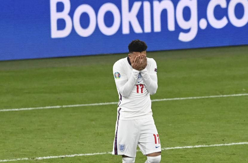 Reaksi pemain Inggris Jadon Sancho setelah kehilangan peluang untuk mencetak gol dalam adu penalti pada pertandingan final sepak bola Euro 2020 antara Italia dan Inggris di stadion Wembley di London, Minggu, 11 Juli 2021.
