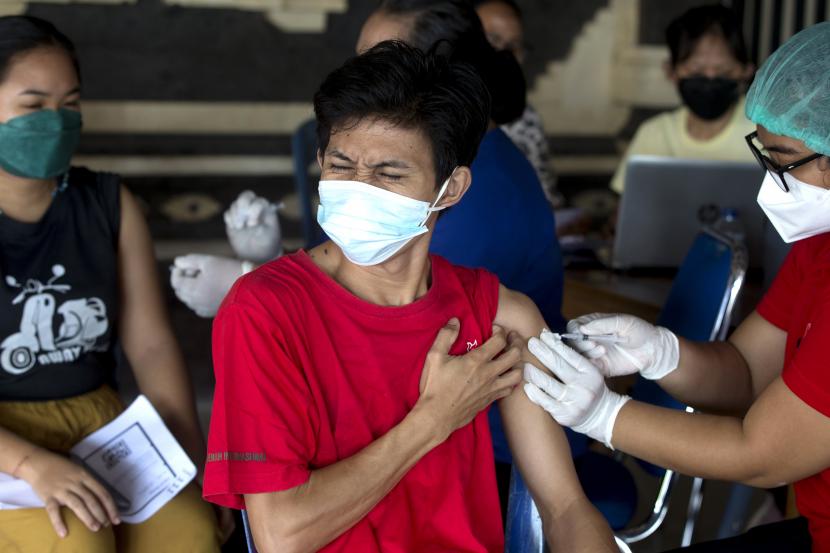Reaksi seorang pria saat menerima suntikan booster Moderna COVID-19 selama kampanye vaksinasi dosis ketiga di Denpasar, Bali, Indonesia pada Sabtu, 29 Januari 2022. 