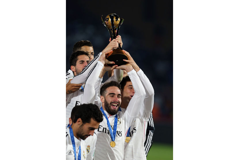 Real Madrid's Dani Carvajal lifts the trophy as his teammates celebrate after their victory in the final final match of the FIFA Club World Cup 2014 between San Lorenzo of Argentina and Real Madrid of Spain, in Marrakech, Morocco, 20 December 2014.