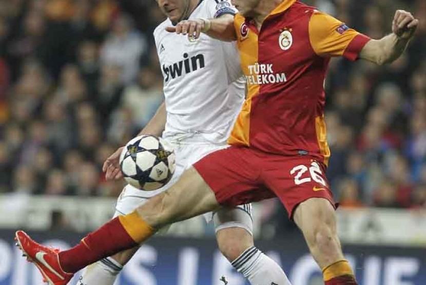 Real Madrid's Karim Benzema from France, left, challenfes Galatasaray's Semih Kaya, right, during the Champions League quarterfinal first leg soccer match between Real Madrid and Galatasaray at the Santiago Bernabeu stadium in Madrid, Wednesday, April 3, 2