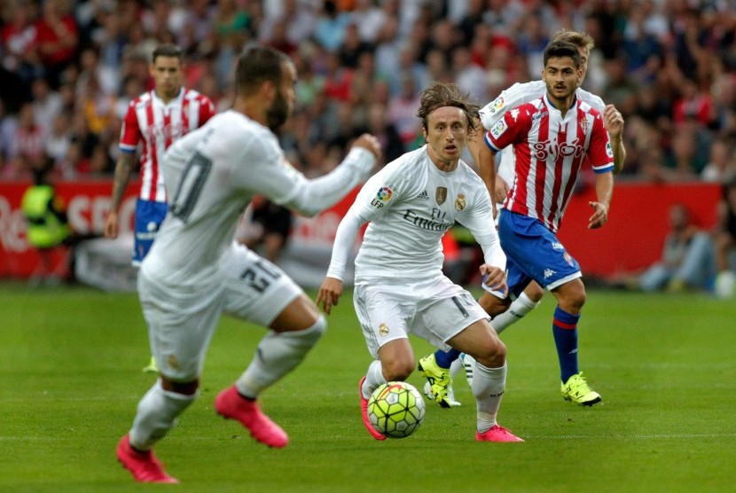 Real Madrid's Luka Modric (C) controls the ball during the Spanish Liga Primera Division soccer against Sporting Gijon match played at El Molinon stadium, in Gijon, northern Spain, 23 August 2015. 