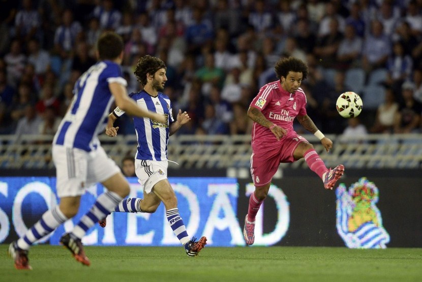 Real Madrid's Marcelo (R) kicks the ball during their Spanish first division soccer match against Real Sociedad at Anoeta stadium in San Sebastian August 31, 2014.