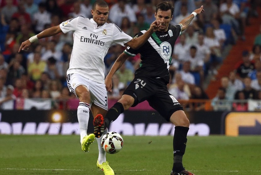 Real Madrid's Pepe (L) and Cordoba's Mike Havenaar challenge for the ball during their Spanish first division soccer match at Santiago Bernabeu stadium in Madrid August 25, 2014.