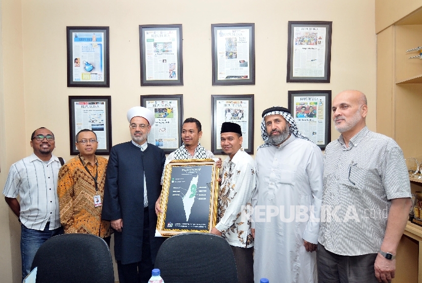 Redaktur Pelaksana Harian Republika Subroto (keempat kiri) menerima penghargaan dari General Secretary Indonesia National Commite for Palestinian People Suhartono Tjipto Basuki (ketiga kanan) didampingi perwakilan redaksi Harian Republika dan Majelis Ulama Palestina di Gedung Harian Republika, Jakarta, Senin (9/10).