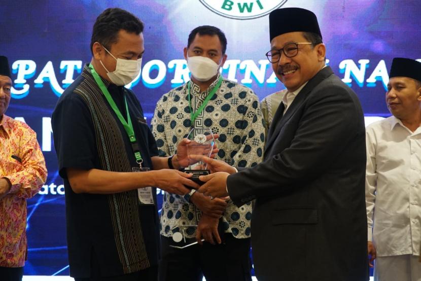 Redaktur Pelaksana Harian Republika Subroto menerima anugerah BWI Award 2022 sebagai Mitra Media Wakaf Nasional dari Wakil Menteri Agama (Wamenag) KH Zainut Tauhid Sa’adi di Rakornas BWI se-Indonesia di Jakarta, Rabu (7/12/2022). 
