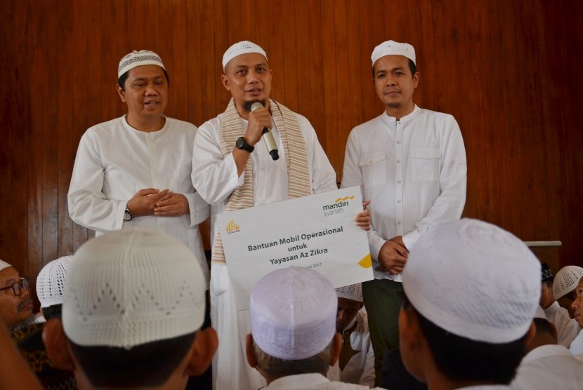 Region Head III Bank Syariah Mandiri Edhie Rosman (kanan) didampingi Branch Manager BSM KC Depok Dua Tamaruddin (kiri) secara simbolik menyerahkan bantuan kendaraan operasional kepada pendiri Yayasan Az-Zikra Ustadz Arifin Ilham (tengah) di Masjid Az-Zikra