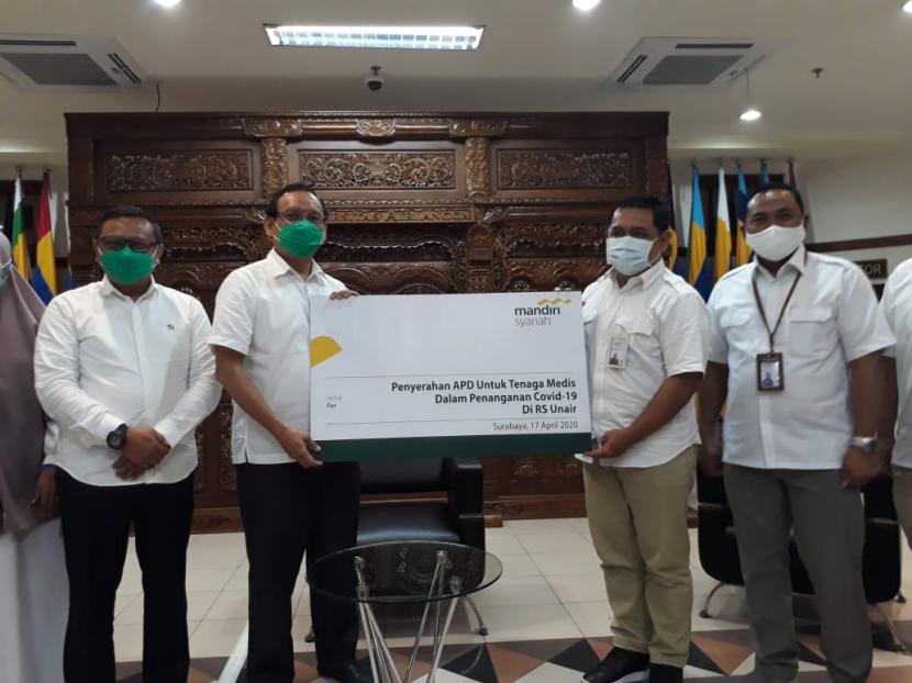 Regional Ceo Mandiri Syariah Surabaya Gunawan Arief Hartoyo (kedua kanan) menyerahkan bantuan APD kepada Rektor Unair Mohammad Nasih (kedua kiri) di Gedung Rektorat Unair, Surabaya (17/4). APD tersebut diperuntikan bagi tim medis dan paramedis yang merawat pasien Covid-19 di Rumah Sakit Universitas Airlangga. 