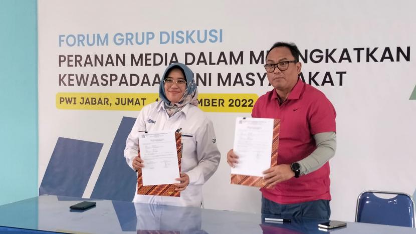 Regional SME Banking Head BRI Regional Office Bandung Nurrohmi Handayani (kiri) dan Ketua PWI Jabar Hilman Hidayat (kanan) usai menandatangani nota kerja sama di Kantor PWI Jabar, Kamis (6/4/2023).
