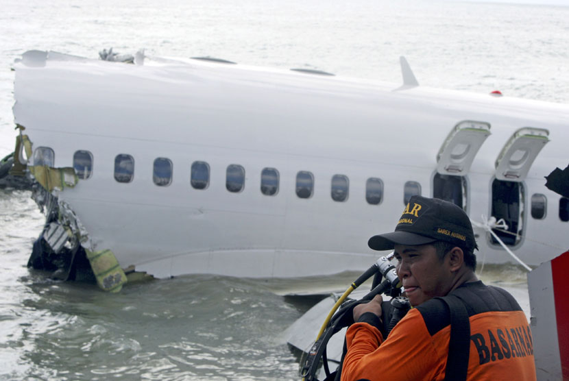 Regu penyelamat bersiap-siap untuk mengambil perekam suara kokpit pesawat Lion Air keluar dari reruntuhan pesawat di dekat Bandara Internasional Ngurah Rai di Kuta, Bali, Senin (15/4).   (AP/ Firdia Lisnawati)