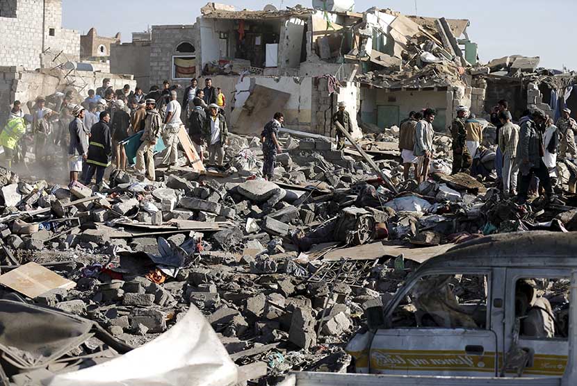  Regu penyelamat mencari korban di reruntuhan gedung yang terkena serangan udara pesawat tempur Arab Saudi di dekat airport Sanaa, Kamis (26/3).