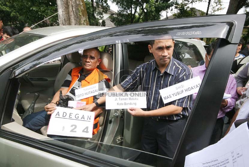   Rekonstruksi penyerahan uang dari mantan Sekda Kota Bandung, Edi Siswadi melalui saksi pegawai Sekda Bandung,Yusuf Hidayat kepada tersangka Toto Hutagalung di Bandung, Rabu (3/7).  (Republika/Edi Yusuf)