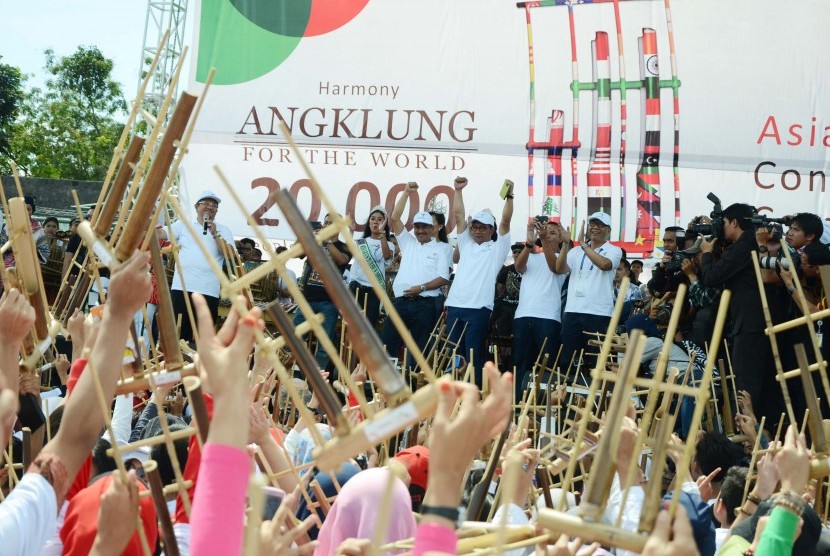 Gubernur Jabar Ahmad Heryawan (kiri), Menteri Pariwisata Arif Yahya (keempat kanan) dan Wali Kota Bandung Ridwan Kamil (ketiga kanan) saat pemecahan rekor “Guinness World Records 20.000 Angklung” di Bandung, Kamis (23/4). (Republika/Edi Yusuf)