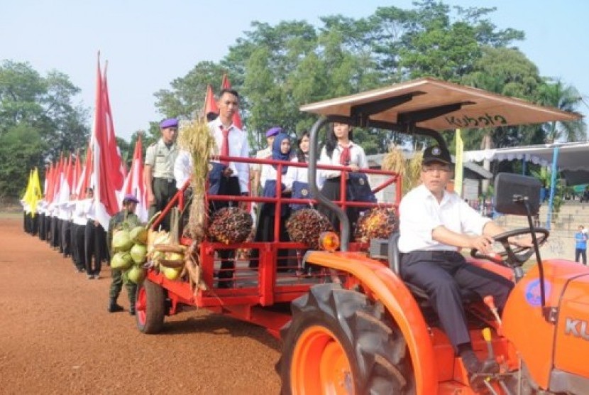 Rektor IPB Prof. Dr. Ir. Herry Suhardiyanto, M.Sc mengemudikan traktor yang membawa perwakilan mahasiswa baru dari berbagai jenjang.