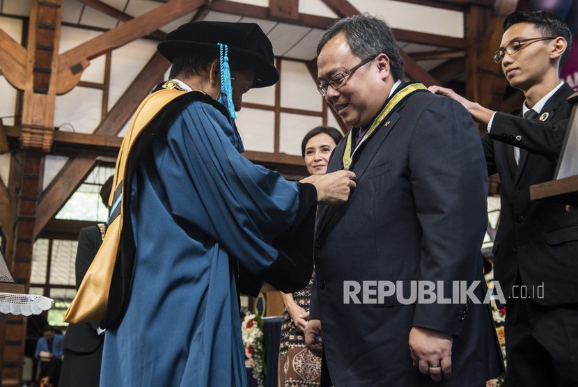 Rektor ITB Kadarsah Suryadi (kiri) menyematkan tanda penghargaan kepada Menteri Perencanaan Pembangunan Nasional (PPN)/Kepala Bappenas Bambang Brodjonegoro (kedua kiri) saat menerima penghargaan pada peringatan ke 98 Pendidikan Tinggi Teknik di Bandung, Jawa Barat, Rabu (4/7). 