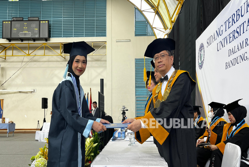 Rektor Taruna Bakti University, Frado Sibarani, Ph.D., M.T., M.B.A., S.Si., CEH, CHFI, menyerahkan ijazah kelulusan pada salah satu wisudawan