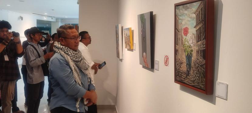 Rektor UII, Fathul Wahid, tengah melihat-lihat lukisan dalam pameran lukisan bertajuk Dari Indonesia ke Palestina: Mencari Harapan di Tengah Perubahan di Selasar Perpustakaan Pusat UII, Senin (7/10/2024).