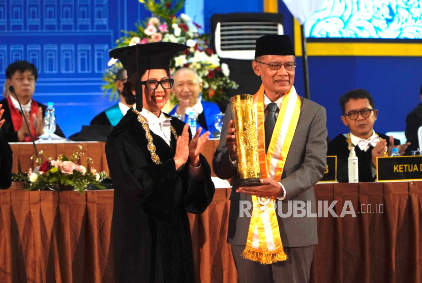 Rektor Universitas Gadjah Mada (UGM) Prof. dr. Ova Emilia, M.Med.Ed., Sp.OG(K)., Ph.D (berdiri, kiri) bersama dengan Ketua Umum Pimpinan Pusat Muhammadiyah Prof Haedar Nashir (kanan) saat penyerahan Anugerah Hamengkubuwono IX di kampus UGM, DI Yogyakarta, Kamis (19/12/2024).