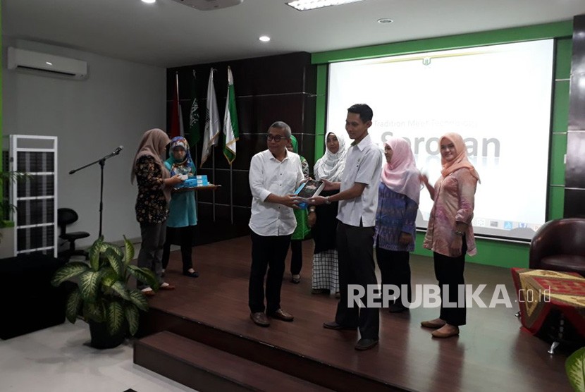 Rektor Universitas Nahdlatul Ulama Surabaya (Unusa) Achmad Jazidie (kiri) secara simbolis menyerahkan tablet e-Sorogan kepada perwakilan mahasiswa baru di Tower Unusa Kampus B, Surabaya, Jumat (6/4).