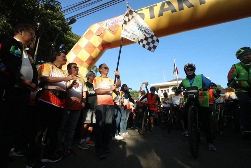 Direktur Teknologi Informasi dan Operasi BNI Dadang Setiabudi  mengibarkan bendera tanda dimulainya event olahraga Padjadjaran Fun Bike pada Sabtu (14/7).